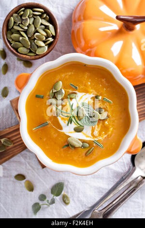 Zuppa di zucca con panna acida, erbe e semi Foto Stock