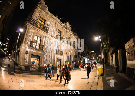 Avenida Francisco I Madero Pedoni Notte Casa de los Azulejos Centro Historico Mexico City | CITTA' DEL MESSICO, Messico — Casa de los Azulejos, un iconico palazzo barocco del XVIII secolo, è illuminato di notte sull'Avenida Francisco I. Madero nel Centro Storico della Città del Messico. Questo edificio è rinomato per la sua facciata ricoperta di piastrelle Talavera blu e bianche di Puebla, Messico. L'Avenida Francisco I. Madero è una vivace zona pedonale, una importante arteria commerciale e culturale della città. Il Centro Storico della Città del Messico (Centro Histórico de la Ciudad de México) è un sito del patrimonio mondiale UNESCO. Foto Stock