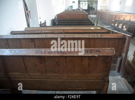 Banchi per giovani uomini all'interno della chiesa di Tutti i Santi, Laxfield, Suffolk, Inghilterra, Regno Unito Foto Stock