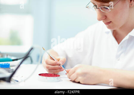 Odontotecnico lavorando su di un tappo di un dente Foto Stock