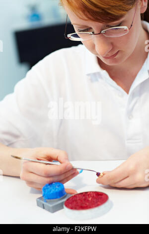 Odontotecnico lavorando su di un tappo di un dente Foto Stock