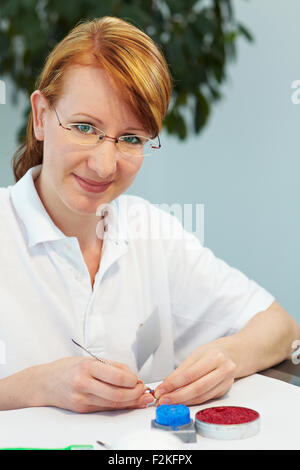 Odontotecnico lavorando su di un tappo di un dente Foto Stock