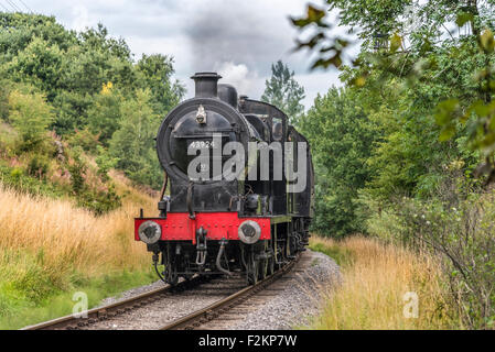 LMS/BR Classe 4F 0-6-0 "Big merci' motore trasporta un treno passeggeri a Haworth stazione sul Keighley e Worth Valley Railway. Foto Stock