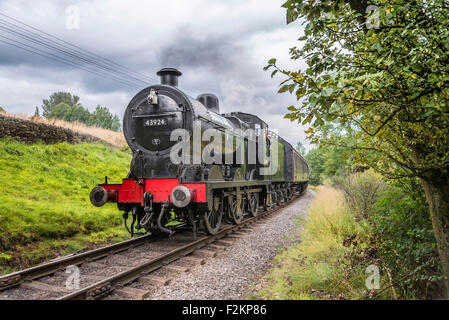 LMS/BR Classe 4F 0-6-0 "Big merci' motore trasporta un treno passeggeri a Haworth stazione sul Keighley e Worth Valley Railway. Foto Stock