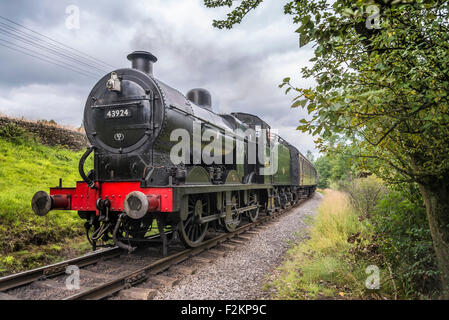 LMS/BR Classe 4F 0-6-0 "Big merci' motore trasporta un treno passeggeri a Haworth stazione sul Keighley e Worth Valley Railway. Foto Stock