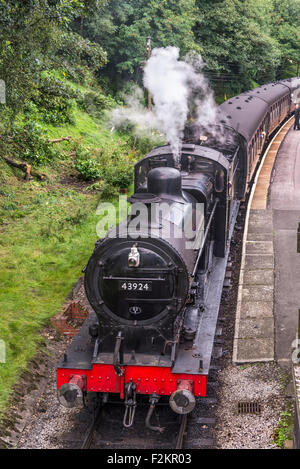 LMS/BR Classe 4F 0-6-0 "Big merci' motore trasporta un treno passeggeri a Haworth stazione sul Keighley e Worth Valley Railway. Foto Stock