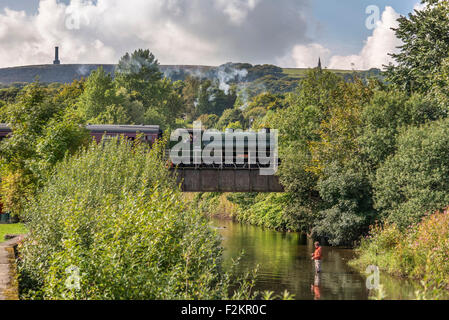 East Lancs ferrovia. WD austerità serbatoio a sella 75008 Swiftsure attraversando il fiume Irwell avvicinando Ramsbottom stazione. Foto Stock