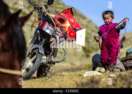 Urumqi. Xvii Sep, 2015. Foto scattata il 7 settembre 17, 2015 mostra un quattro-anno-vecchio ragazzo in viaggio con la sua famiglia di pastori che si sono occupati di trasferire le loro mucche e pecore al pascolo invernale in Prefettura degli Altai del nord-ovest della Cina di Xinjiang Uygur Regione autonoma. Come l'estate è arrivata alla sua fine, locale Kazak pastore famiglie qui ha iniziato a spostare le loro mandrie nei pascoli invernali. © Shen Qiao/Xinhua/Alamy Live News Foto Stock