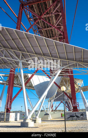 Vista parte inferiore della protezione solare scultura e di Lisbona 25 de Abril Bridge. Foto Stock