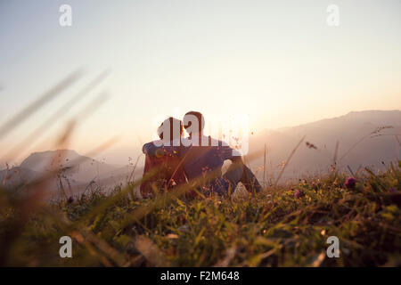 Austria, Tirolo, Unterberghorn, due escursionisti in appoggio nel paesaggio alpino al tramonto Foto Stock