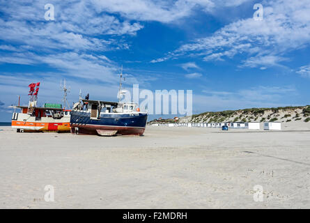 Danese di piccole barche da pesca spiaggiata a Loekken nel Nord dello Jutland con dune di sabbia e spiaggia di capanne in background Foto Stock