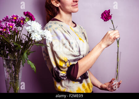 Giovane donna con un unico fiore nella sua mano Foto Stock