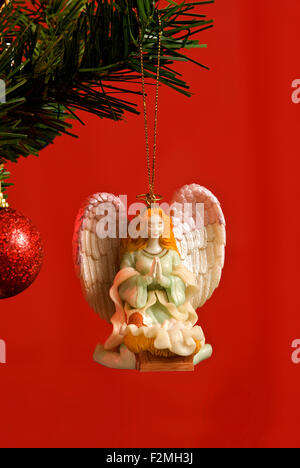 Bella Christmas Angel ornamento colpo verticale su sfondo rosso Foto Stock