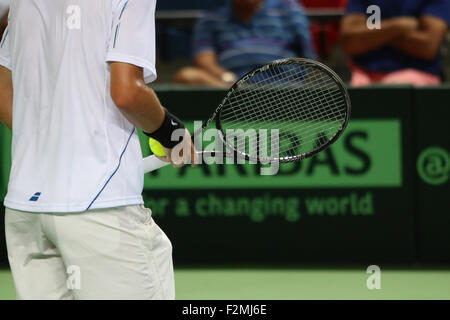 Giocatore di Tennis in bianche vesti pronto a servire una palla Foto Stock