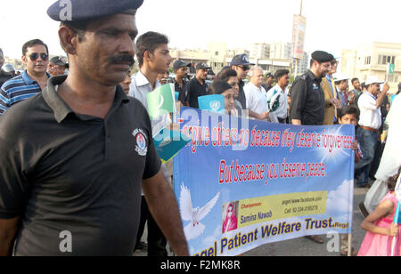 Sindh personale di polizia e i membri della società civile sono in possesso di una pace a piedi passando attraverso la strada vicino a Clifton Beach di Karachi lunedì 21 settembre, 2015. Durante la passeggiata di polizia Sindh musicali della band hanno suonato brani di pace mentre i partecipanti cantano slogan contro gli assassini del bersaglio, estorsione mafia e terra di mafie di Karachi. Foto Stock