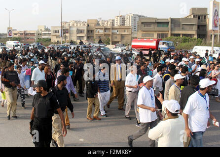 Sindh personale di polizia e i membri della società civile sono in possesso di una pace a piedi passando attraverso la strada vicino a Clifton Beach di Karachi lunedì 21 settembre, 2015. Durante la passeggiata di polizia Sindh musicali della band hanno suonato brani di pace mentre i partecipanti cantano slogan contro gli assassini del bersaglio, estorsione mafia e terra di mafie di Karachi. Foto Stock