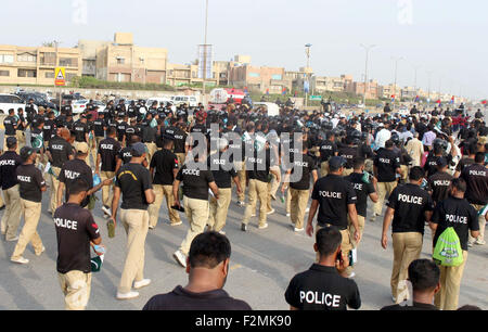 Sindh personale di polizia e i membri della società civile sono in possesso di una pace a piedi passando attraverso la strada vicino a Clifton Beach di Karachi lunedì 21 settembre, 2015. Durante la passeggiata di polizia Sindh musicali della band hanno suonato brani di pace mentre i partecipanti cantano slogan contro gli assassini del bersaglio, estorsione mafia e terra di mafie di Karachi. Foto Stock