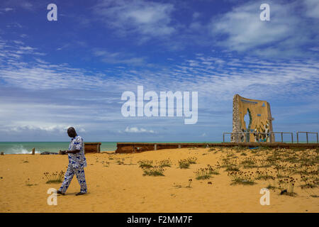 Il Benin, Africa Occidentale, Ouidah, uomo passando davanti al memoriale del grande Giubileo del 2000 Foto Stock