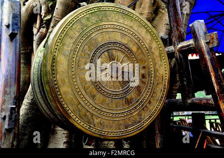 Ping Le antiche città, Cina: un riccamente decorate appesi tamburo di ottone sostenuto mediante la rastremazione palo di bambù Foto Stock