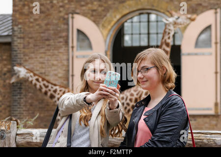 Due adolescenti che si ritrattano da soli allo ZSL London Zoo, Londra Inghilterra Regno Unito Foto Stock