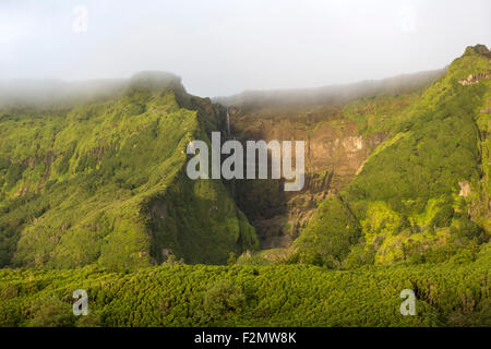 Le scogliere di montagna con cascate flusso sopra il bordo vicino Fajazinha, sull isola di Flores, Azzorre, Portogallo Foto Stock