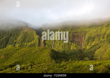 Le scogliere di montagna con cascate flusso sopra il bordo vicino Fajazinha, sull isola di Flores, Azzorre, Portogallo Foto Stock