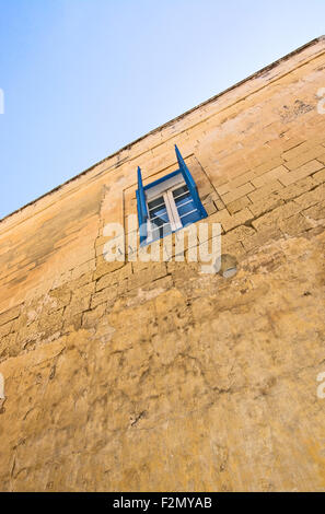 Blu aperto nella finestra dell'otturatore all'interno di mura della città vecchia in una giornata di sole in settembre a Malta. Foto Stock