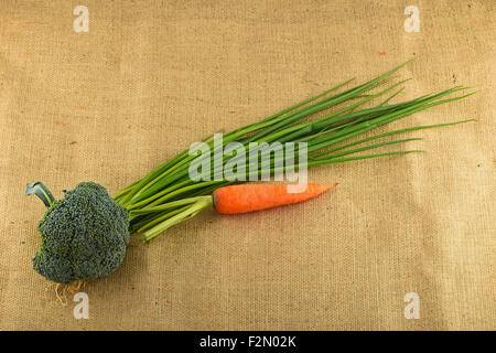 Estate artigianale di verdure e verdi in tela, raggrinzimento verde cipolline, una carota e broccoli freschi Foto Stock