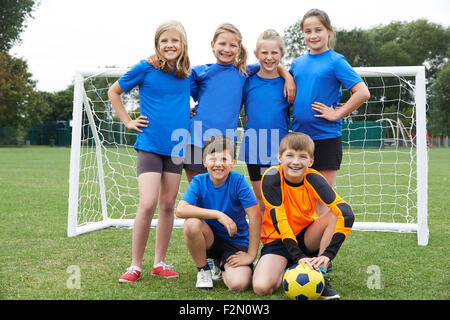 Ragazzi e Ragazze nella scuola elementare di calcio Foto Stock