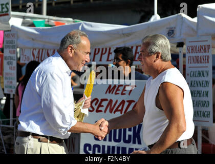 Bellmore, New York, Stati Uniti d'America. Xx Settembre 2015. Stati Uniti Il senatore Charles (mandrino) SCHUMER (Democratico - New York) stringe la mano con un equo-goer e mangia sulla pannocchia di mais alla 29a Bellmore annuale famiglia Street Festival, dotate di divertimento per tutta la famiglia con mostre e attrazioni, con oltre centomila persone che dovrebbero partecipare nel corso del fine settimana. Credito: Ann e Parry/Alamy Live News Foto Stock