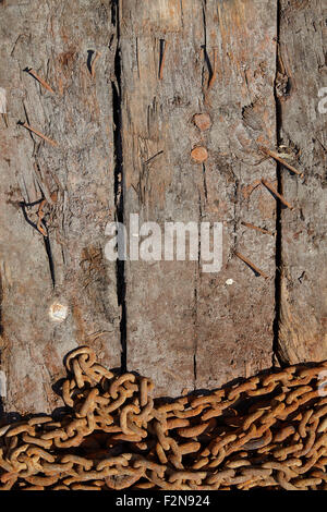 Rusty catena di ferro su una texture di legno sfondo Foto Stock