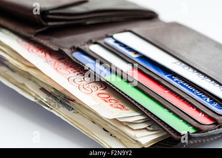 Apri Wallet che mostra British sterline in varie banconote, carte di credito e di debito Foto Stock