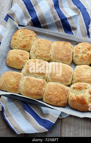 Pane appena sfornato focaccine fatte in casa in una teglia da forno su una tavola di legno Foto Stock