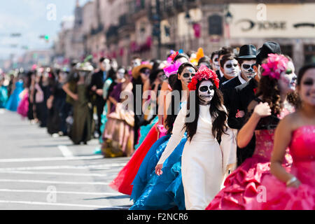 Coppie giovani, costume come 'La Catrina', a piedi attraverso la città durante il giorno dei morti festeggiamenti in Morelia, Messico. Foto Stock