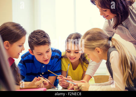 Un gruppo di ragazzi in età scolare la scrittura dei test in aula Foto Stock