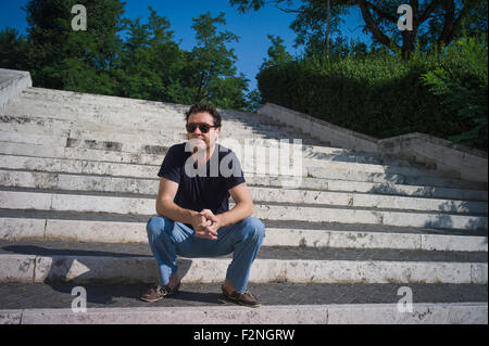 Uomo caucasico seduti sulla scalinata all'aperto Foto Stock