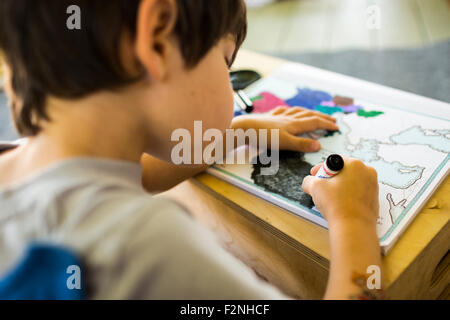 Razza mista boy mappa di colorazione con matita colorata Foto Stock