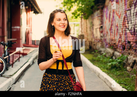 La donna caucasica camminando in una strada di città Foto Stock