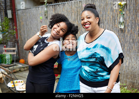 Figlia della madre e zia rilassante in cortile Foto Stock