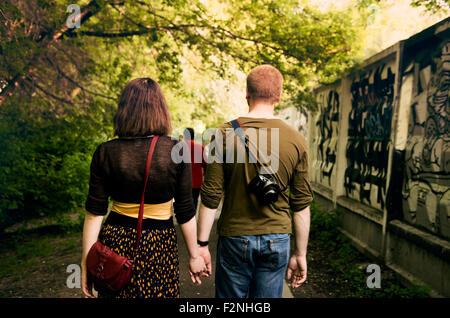 Coppia caucasica tenendo le mani nel parco urbano Foto Stock