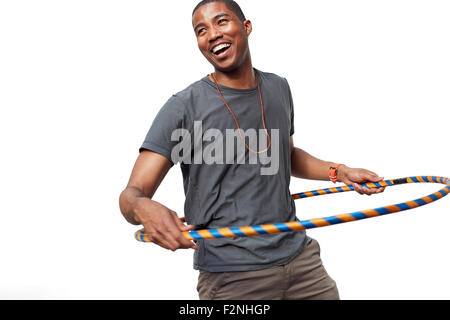 Uomo sorridente giocando con cerchio in plastica Foto Stock