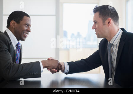 Uomini d'affari si stringono la mano in office meeting Foto Stock