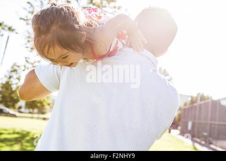 Padre ispanica che trasportano figlia sulle spalle Foto Stock