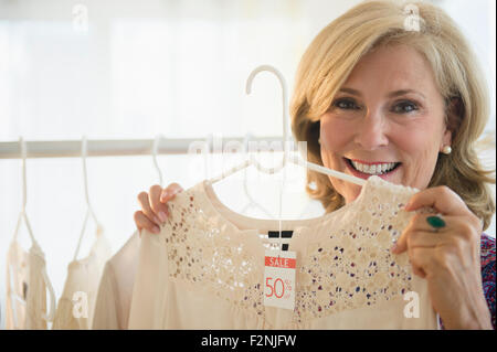 La donna caucasica shopping nel negozio di abbigliamento Foto Stock