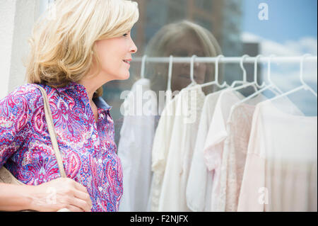 La donna caucasica shopping nel negozio di abbigliamento Foto Stock