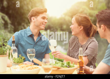 Amici a cena party in cortile Foto Stock