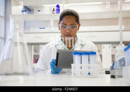 Razza mista di scienziato con tavoletta digitale in laboratorio Foto Stock