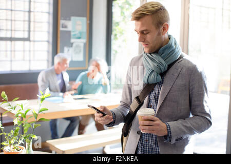 Imprenditore utilizzando il cellulare in ufficio Foto Stock