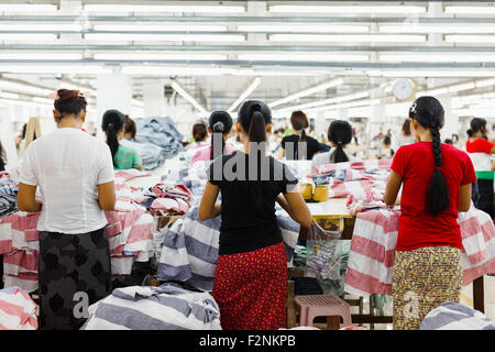 I lavoratori asiatici cucire vestiti in fabbrica di indumento Foto Stock