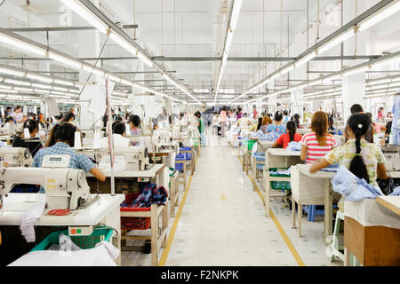 Lavoratori asiatici cucire vestiti in fabbrica di indumento Foto Stock